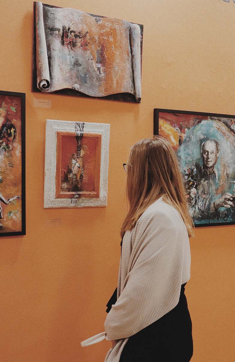 art gallery woman wearing white long-sleeved blouse looking at phoo human